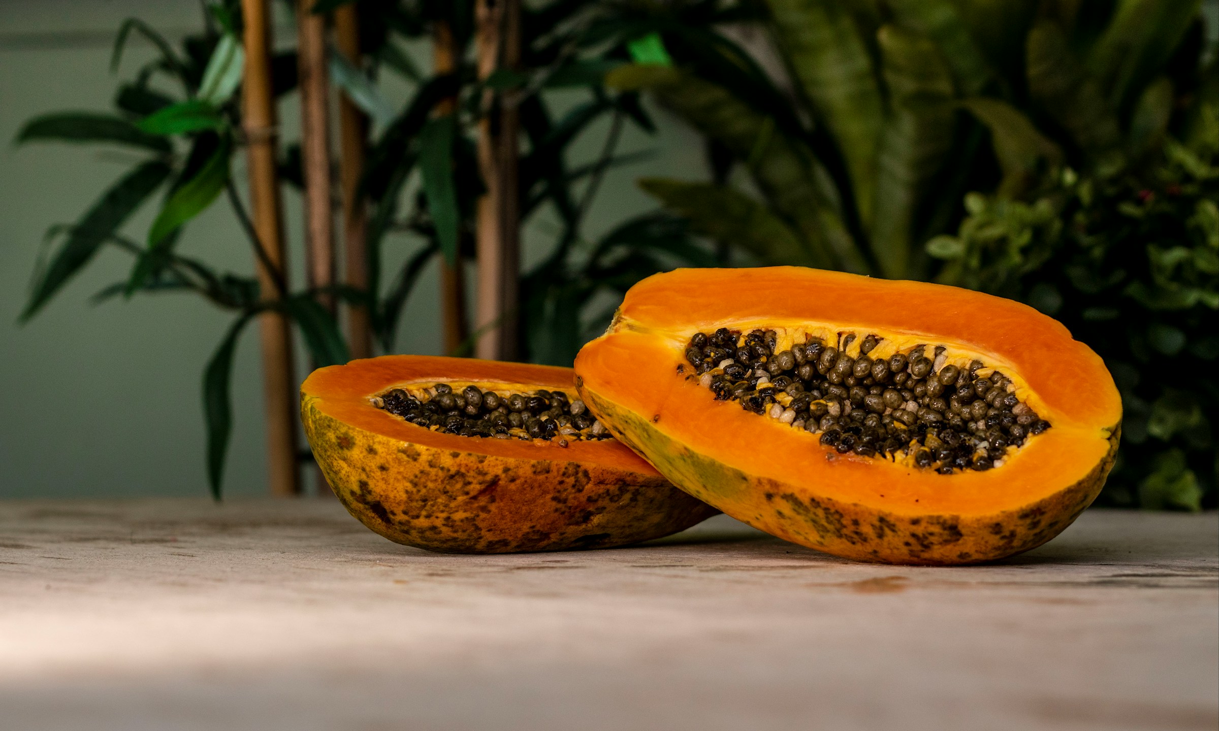 Whole papaya with seeds on a wooden table -- used in parasite cleanse